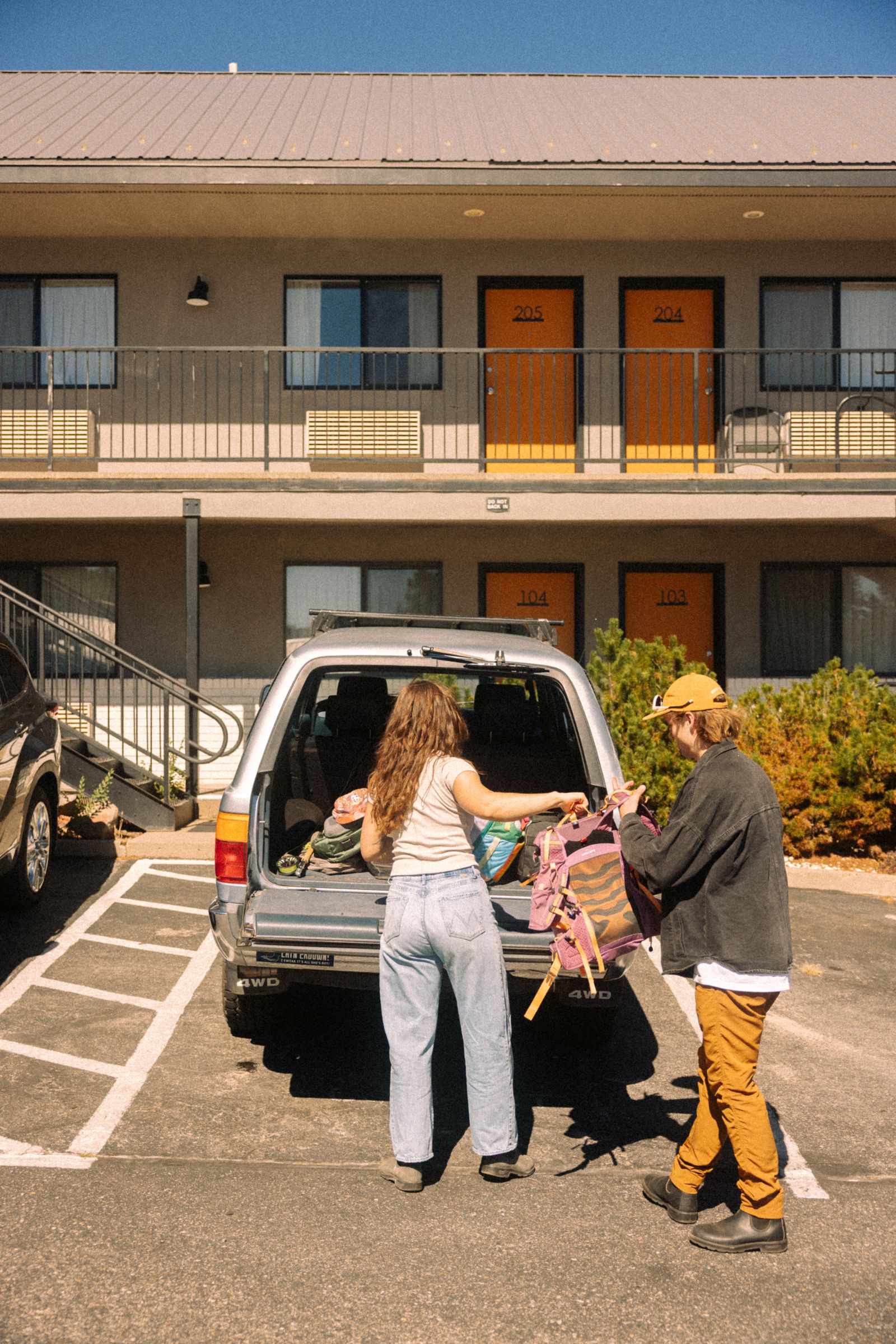 Guests unloading gear from their car outside their room at Adventure Inn Durango
